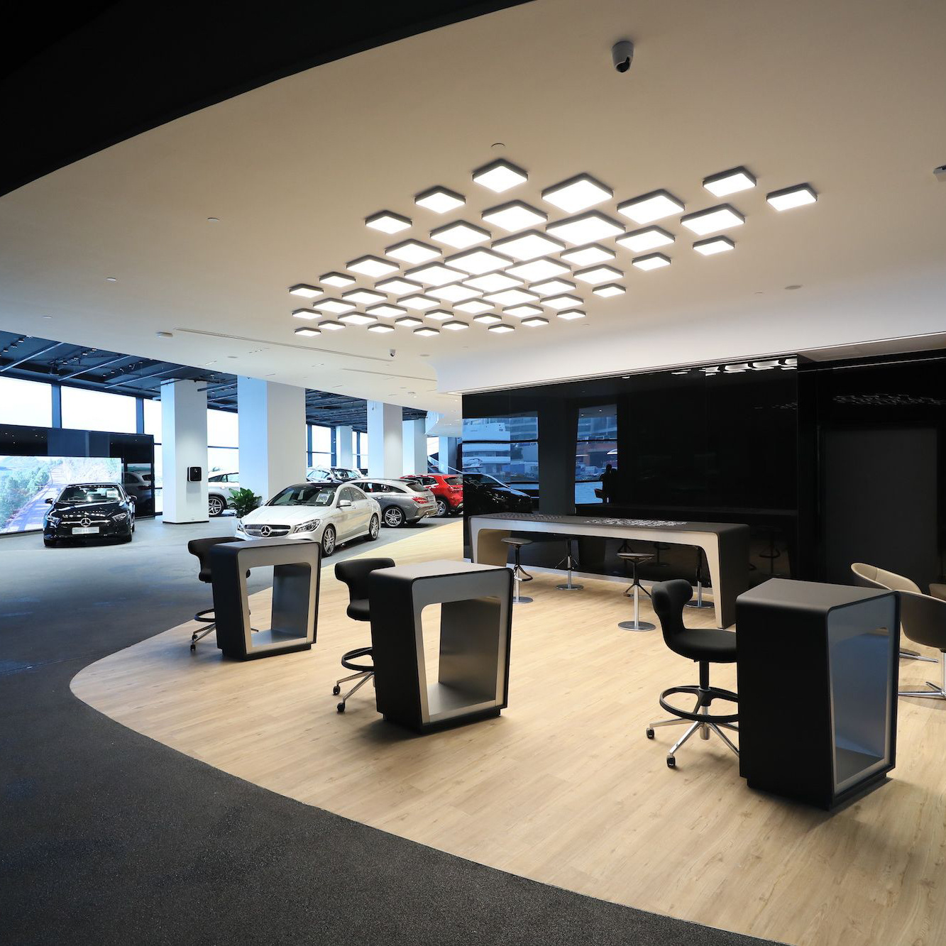 Automotive showroom feature area illuminated by custom LPA Lighting solutions, showcasing a premium vehicle with focused accent lighting and integrated smart controls for enhanced visual impact.
